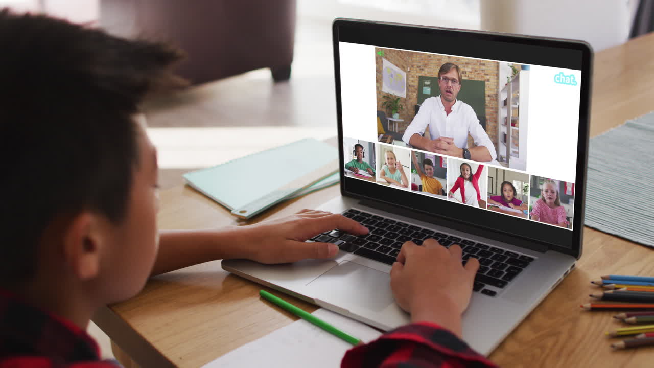 escolar que usa una computadora portátil para una lección en línea en casa, con un maestro y una clase diversos en la pantalla