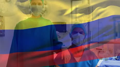 Animation-of-waving-colombia-flag-against-portrait-of-caucasian-male-and-female-surgeon-at-hospital