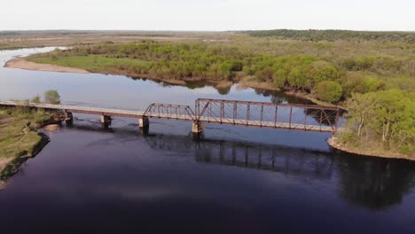 Vista-Panorámica-Aérea-Del-Viejo-Puente-De-Metal-A-Través-De-Un-Río