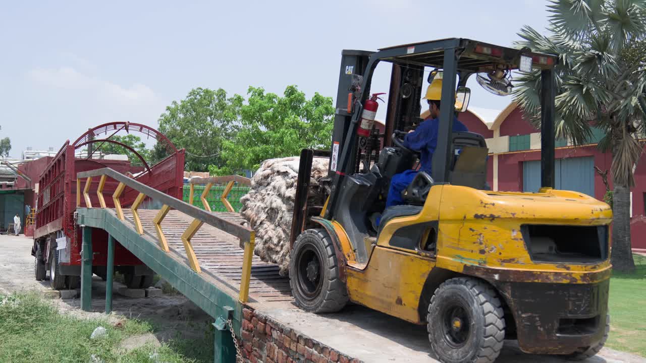 Forklift Loading Cotton Bales onto Truck at a Factory