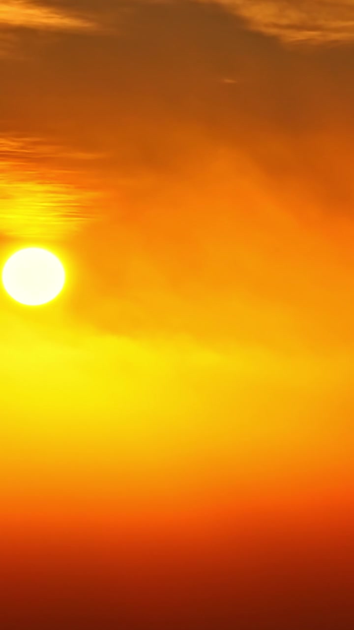 The sun casts a golden glow across the sky, creating a vibrant and warm atmosphere. Ideal for use in nature documentaries or travel content emphasizing sunsets.