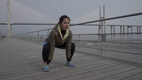 concentrated hindu woman exercising on wooden pier