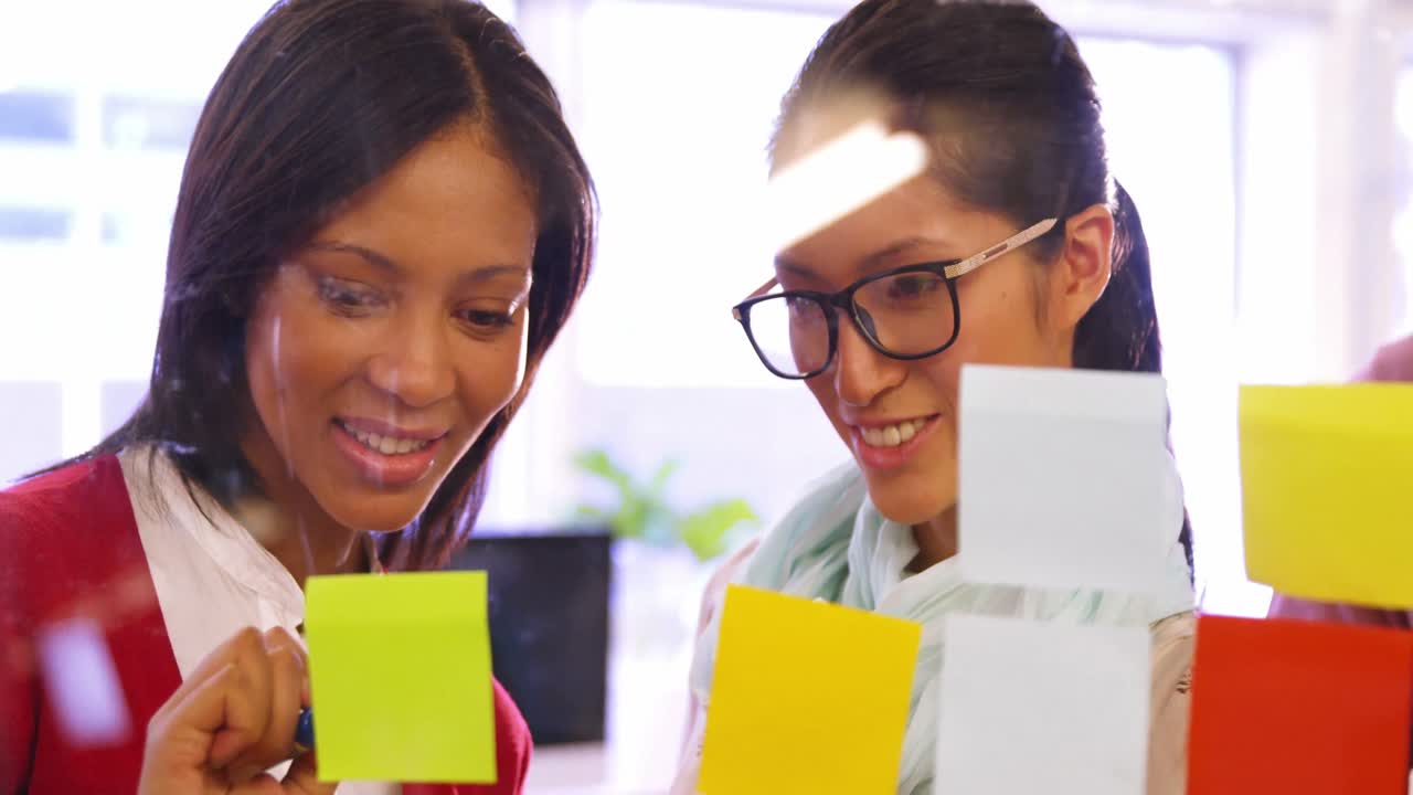 mujeres ejecutivas de negocios leyendo notas adhesivas