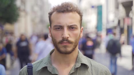 giovane uomo che guarda la telecamera in una strada della città moderna.