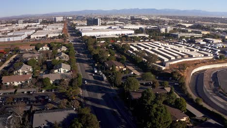 aerial wide shot of a south bay industrial neighborhood with downtown los angeles far in the distance