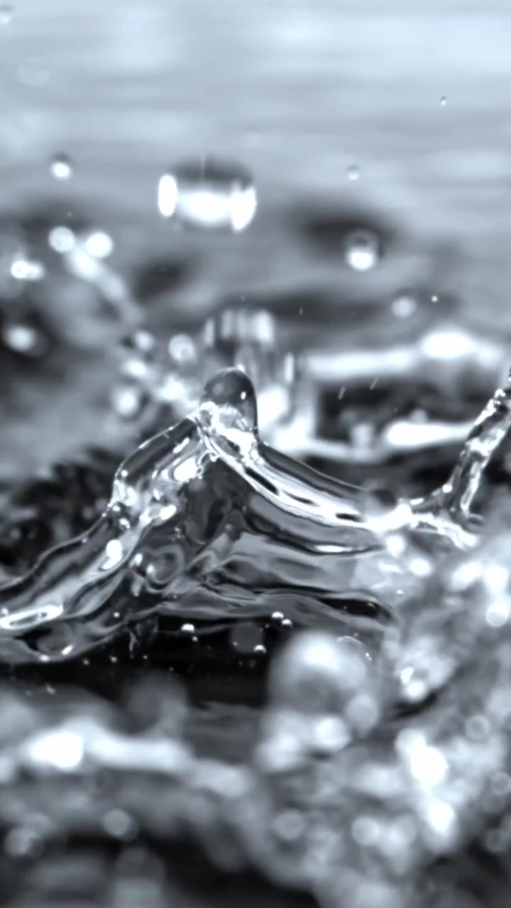 Slow Motion Close-Up of Rain Drops Splashing on Water Surface