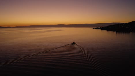 Flying-away-from-sailboat-on-Lake-Léman-with-beautiful-sunset-colors-In-front-fo-Cully,-Lavaux---Switzerland