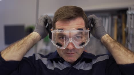 a car mechanic putting on plastic protection glasses