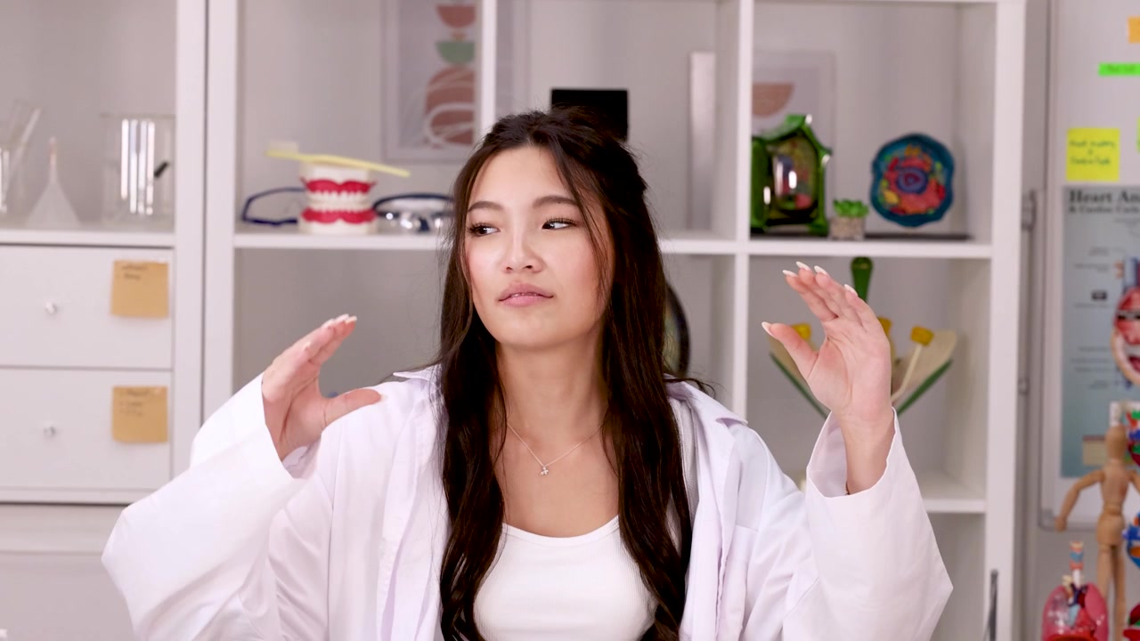 นักวิทยาศาสตร์หญิงสาวอธิบายแนวคิดในห้องปฏิบัติการ
