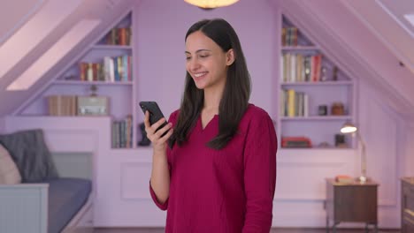 Happy-Indian-girl-looking-at-phone