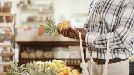 Mid-section-of-senior-african-american-man-shopping-at-health-food-shop,-slow-motion