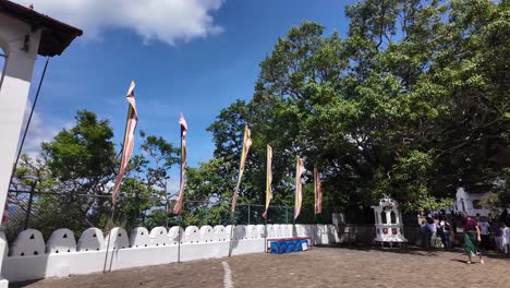 colorful buddhist flags flutter in the breeze at the historic dambulla cave temple, sri lanka, under a vibrant blue sky, evoking a sense of spirituality and peace.