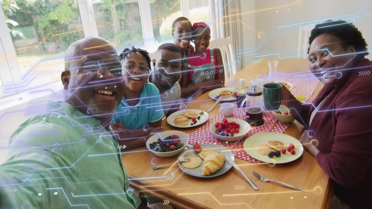 Family around dining table rotating toward smartphone capturing group selfie with tech overlay