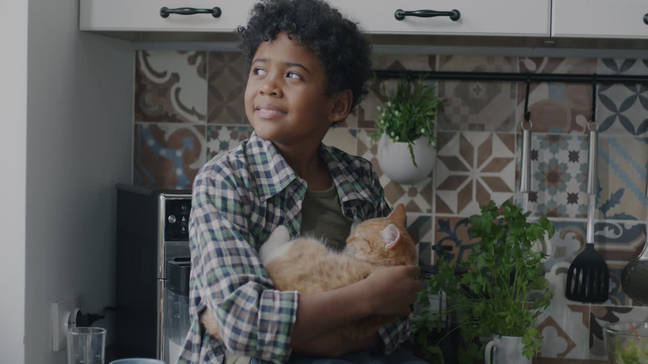 Anak Laki-laki Memegang Kucing di Dapur