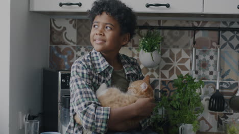 boy holding a cat in the kitchen