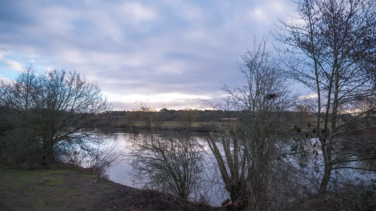 En stillestående timelapse-optagelse af flodbredden ved floden Little Ouse i det østlige England under solopgang.