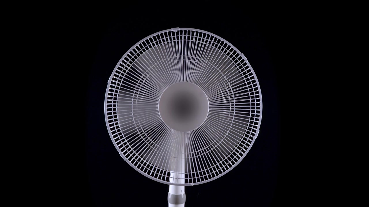 Hvid oscillerende ventilator centreret mod en sort baggrund med blæserhovedet