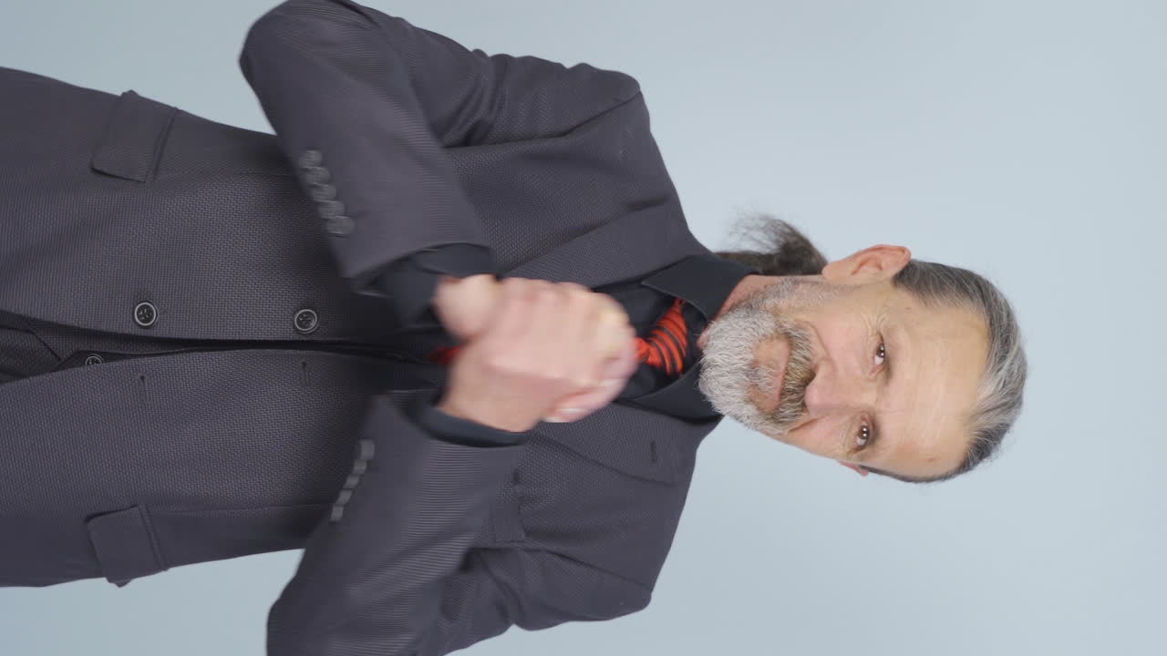 video vertical de un viejo hombre de negocios haciendo una señal de confianza en la cámara.