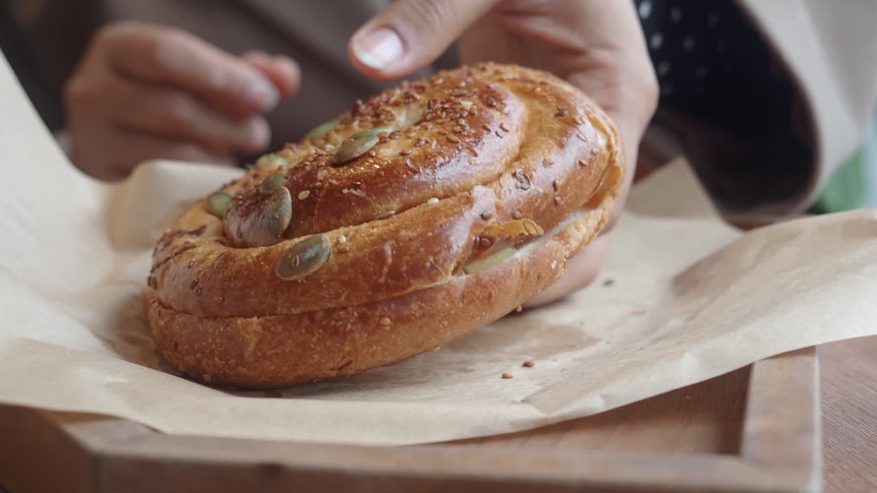 Primo piano di una mano che prende un dolce ai semi da un vassoio