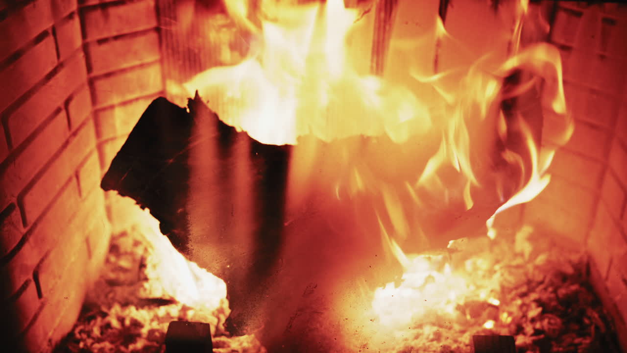 Legna da ardere in un caminetto con braci incandescenti e fiamme calde