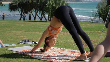 slim girl practicing yoga on mat doing downward dog pose - downward-facing dog pose - burleigh hill and beach in summer - gold coast, qld, australia