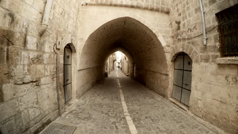 arche from overbuilt passage under narrow ancient street paved with stones in urfa