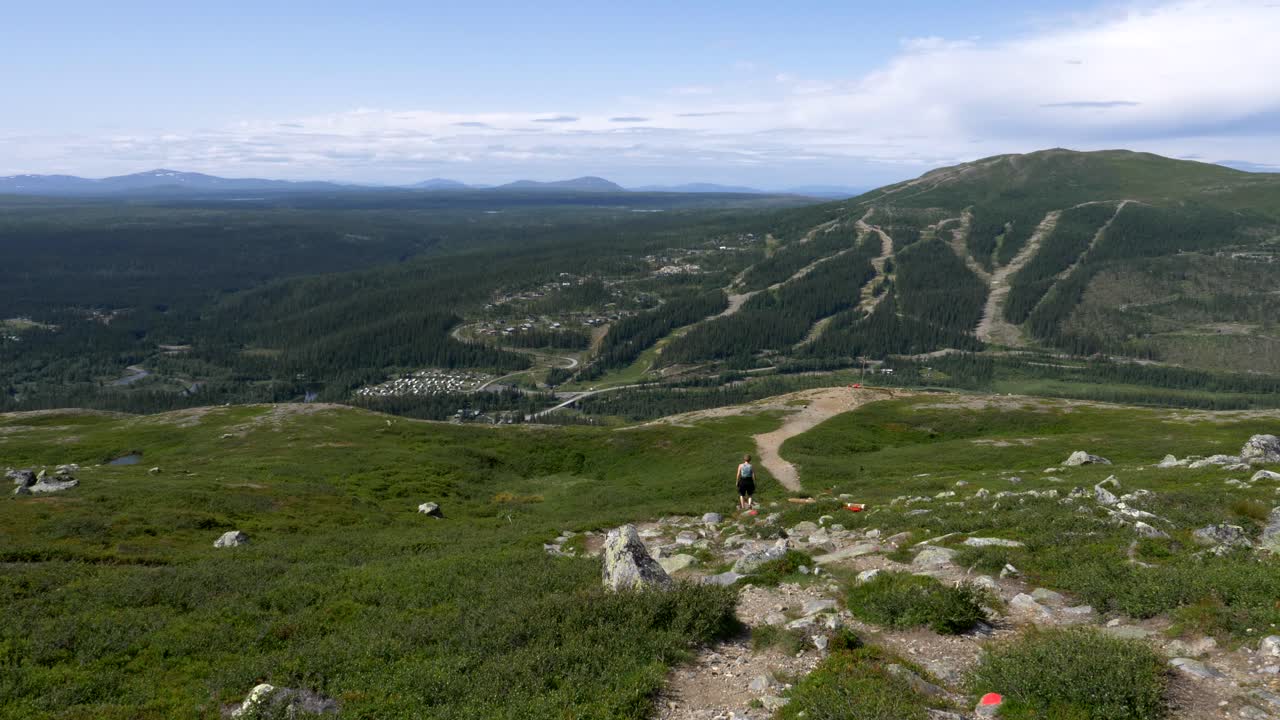 impresionante paisaje montañoso ártico, una mujer adulta caminando por la cordillera siguiendo la ruta de senderismo, jamtland, suecia