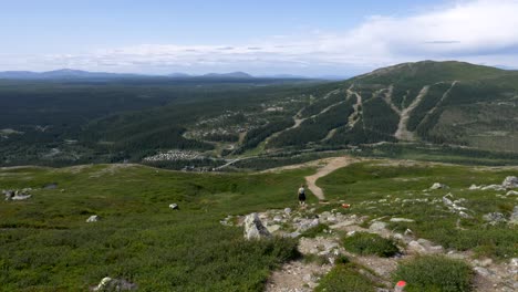 adembenemend arctisch berglandschap, een volwassen vrouw die door de bergketen loopt en het wandelpad volgt, jamtland, zweden