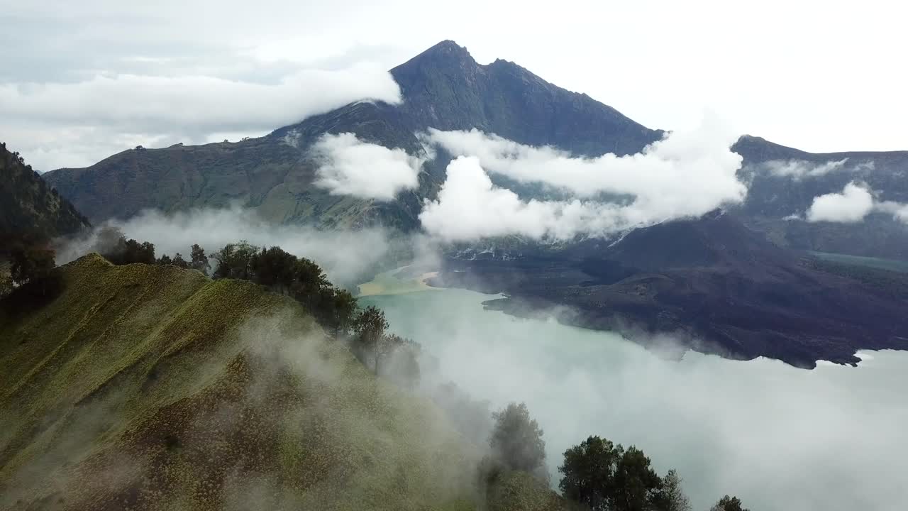 panorámica aérea de 4k del monte rinjani brumoso con el lago del cráter a la vista, indonesia