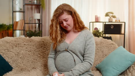 pregnant young woman wiping tears at home holding belly emotional and sensitive moment of pregnancy
