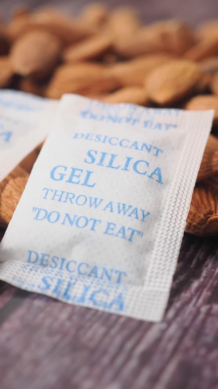 Bustine di gel di silice essiccante con etichetta di avvertenza accanto alle mandorle