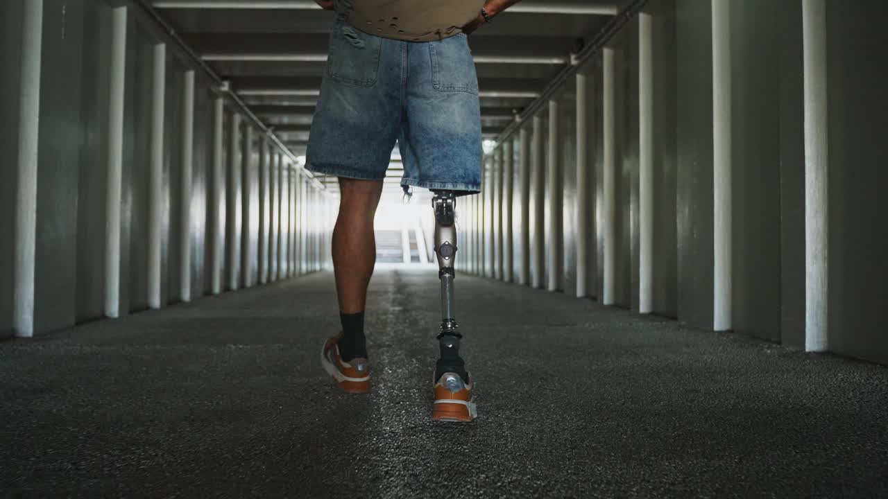 Person with prosthetic leg walking through a tunnel