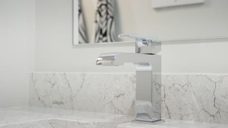 close-up of a modern chrome bathroom faucet with running water