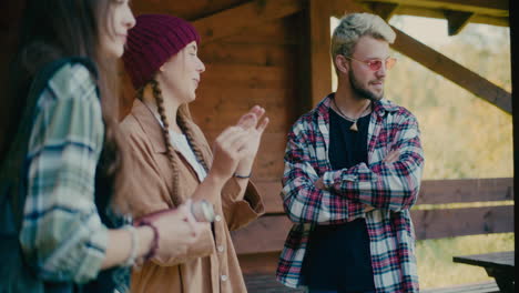 hombre joven de pie con mujeres hablando durante las vacaciones