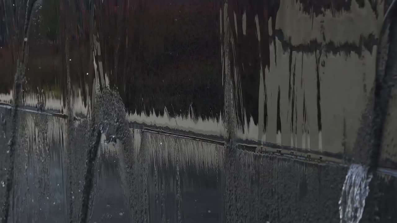 Water falling off of a fountain wall into water in 120 fps slow motion