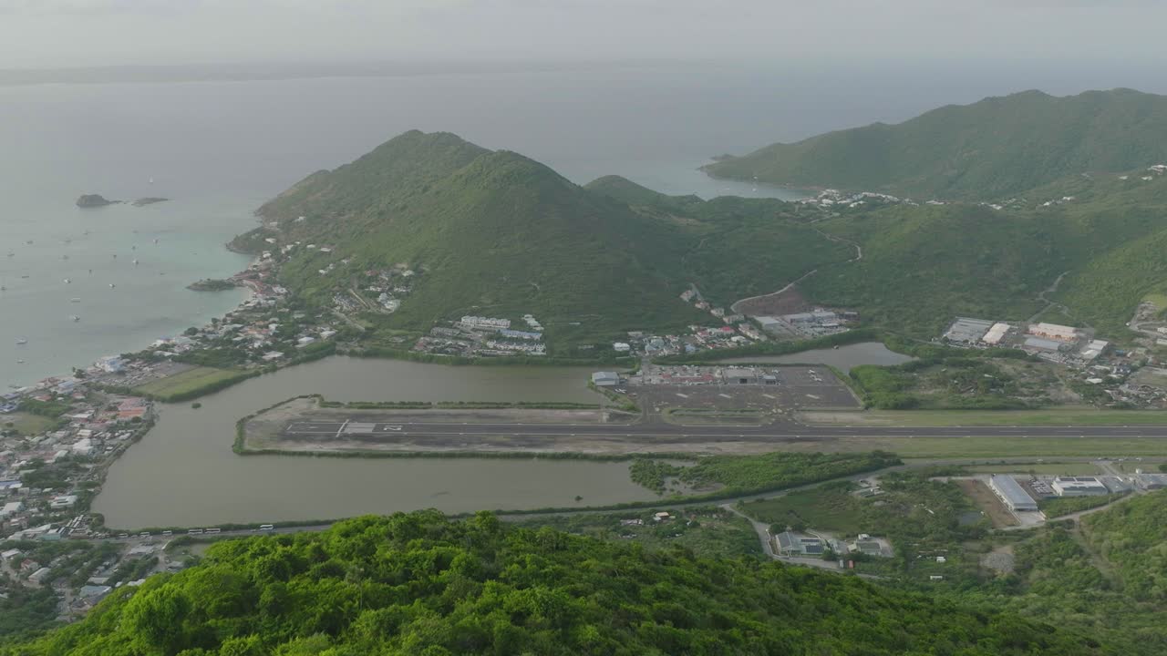 세인트 마틴의 초록색 산과 함께 그랜드 케이스 공항의 후방 촬영