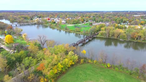 a beautiful drone flight over breathtaking fall trees and leaves changing colors along the rock river in small midwest town rockton, illinois