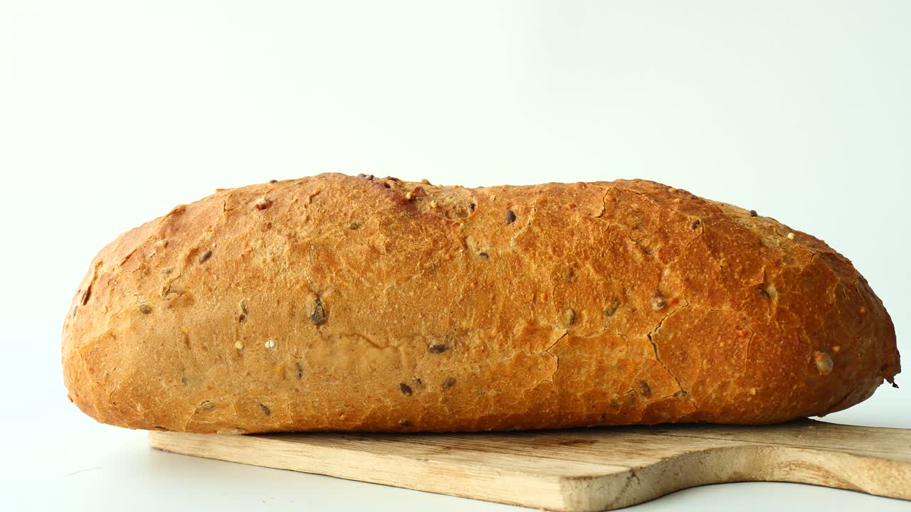 свежевыпеченный цельнозерновый хлеб на деревянной доске для резки