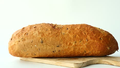 pan de grano entero recién horneado en una tabla de cortar de madera