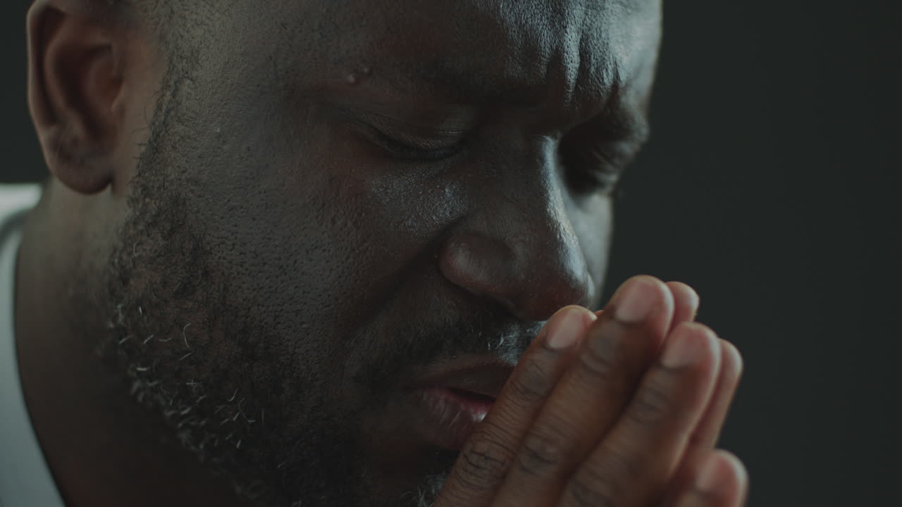 Religious Black Man Praying for Hope with Hands Together