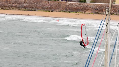 windsurfista realizando un salto cerca de la orilla