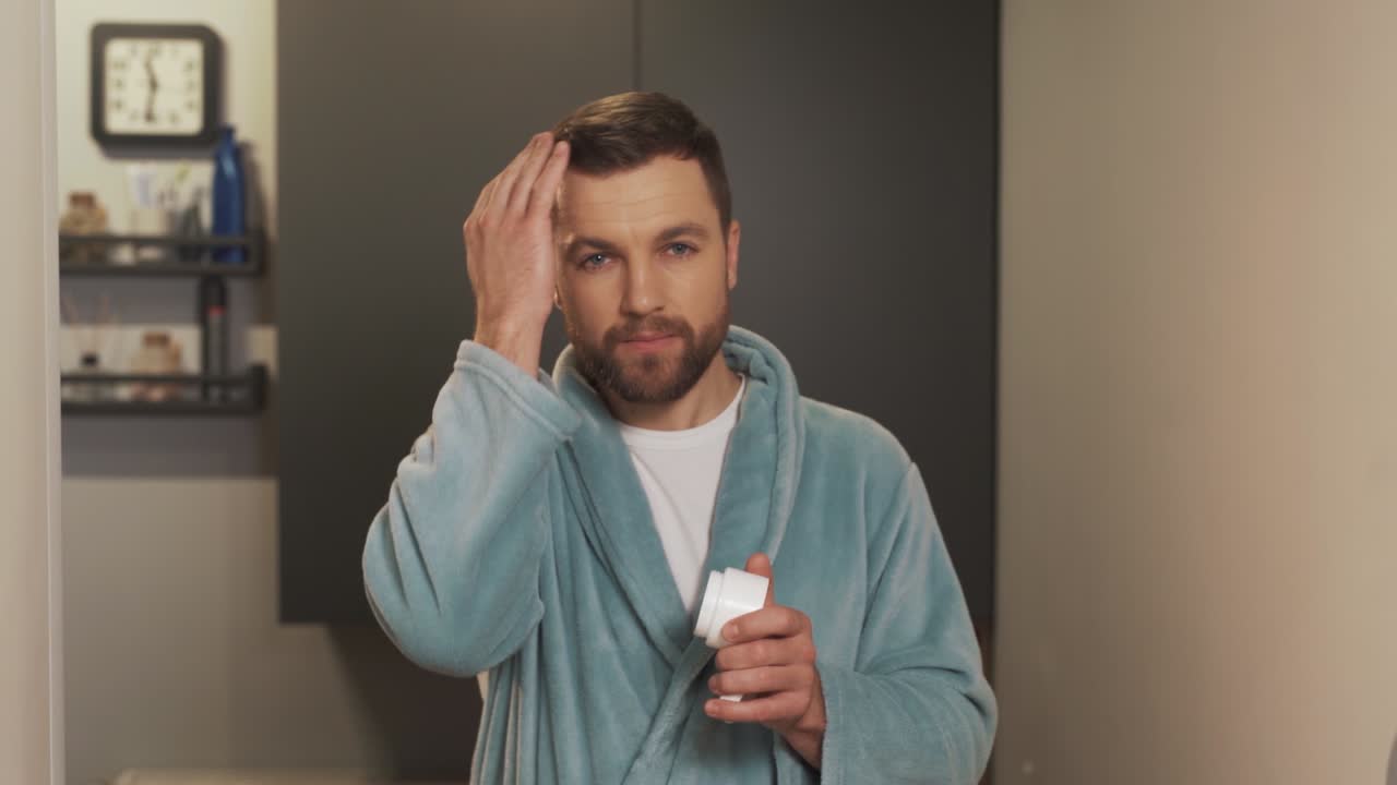 만족한 남자는 손가락에 왁스를 바르기 위해 머리를 감는다