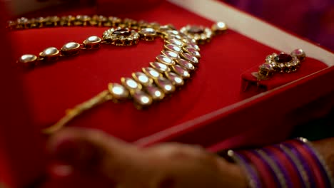a female checking out kundan jewellery set / necklace set for festive preparation