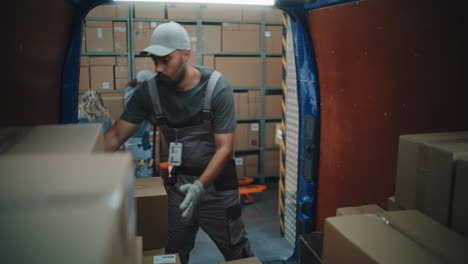 logistics workers loading and unloading boxes from a delivery van at a warehouse