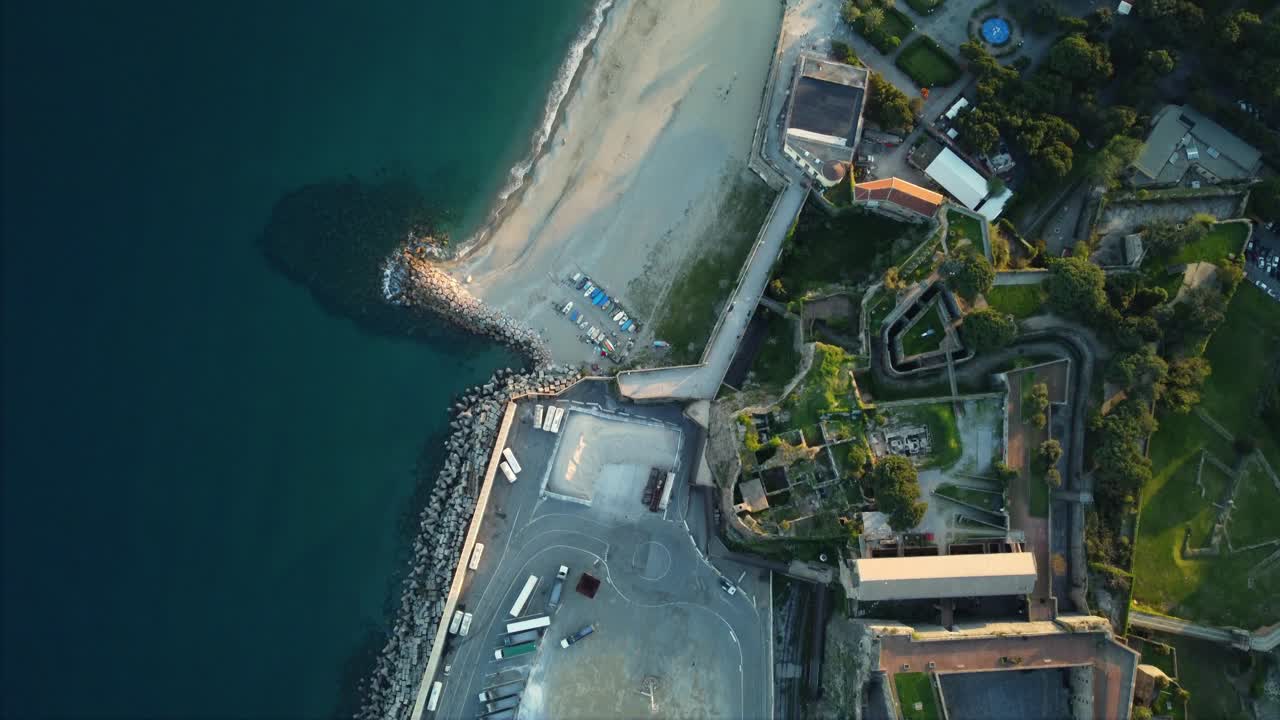 Aerial view of a beach, coast, ocean, fortress, and buildings