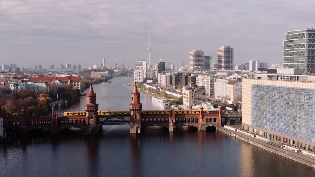 Luftfoto med tilgang mod Oberbaumbrücke, hvor et hurtigt metrotog krydser, Berlin