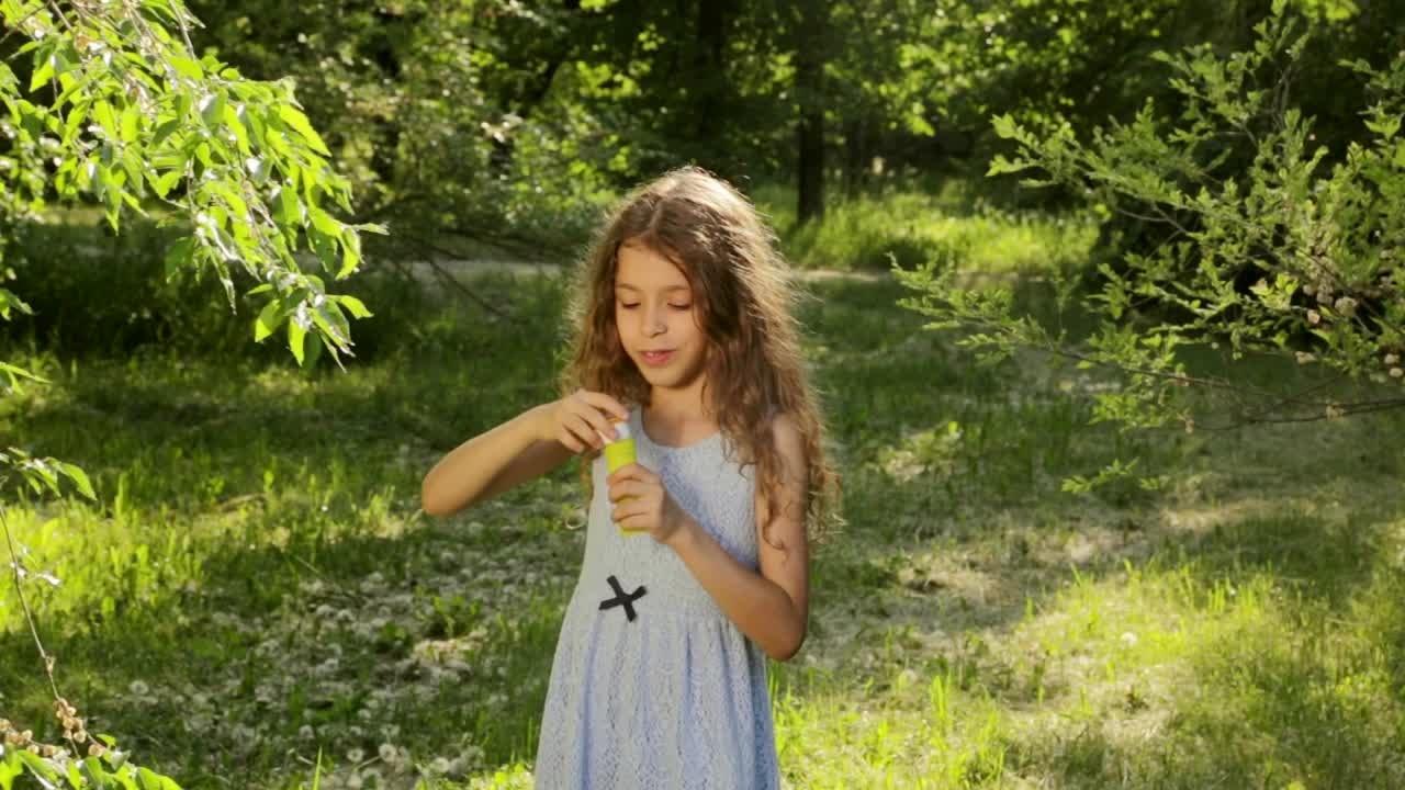 공원에서 거품을 불어넣는 소녀