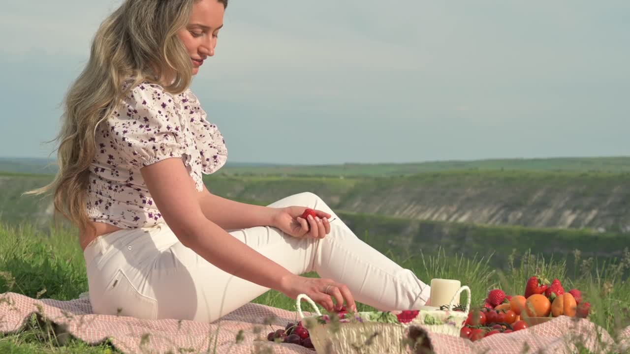 Woman relaxing and eating fruit at a picnic in nature