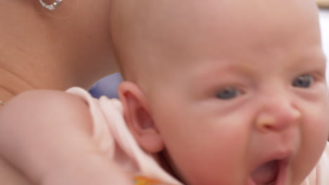 una niña adormecida en las manos de su madre