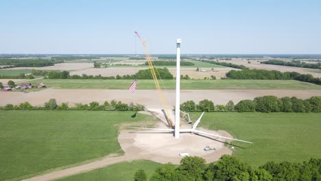 Construction-of-wind-turbine-in-fields-of-rural-America,-aerial-orbit-view